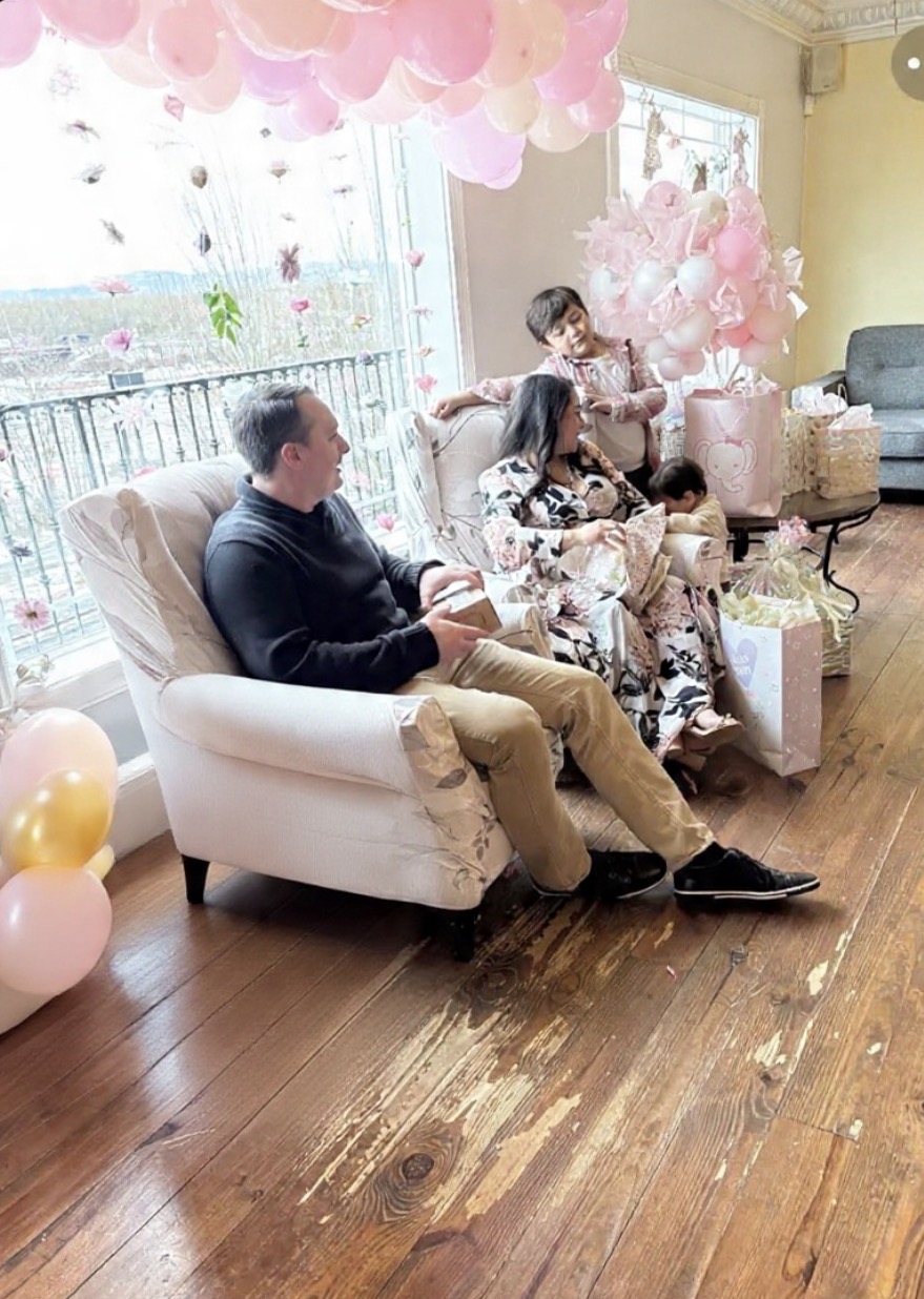 Family opening gifts at a pink themed baby shower